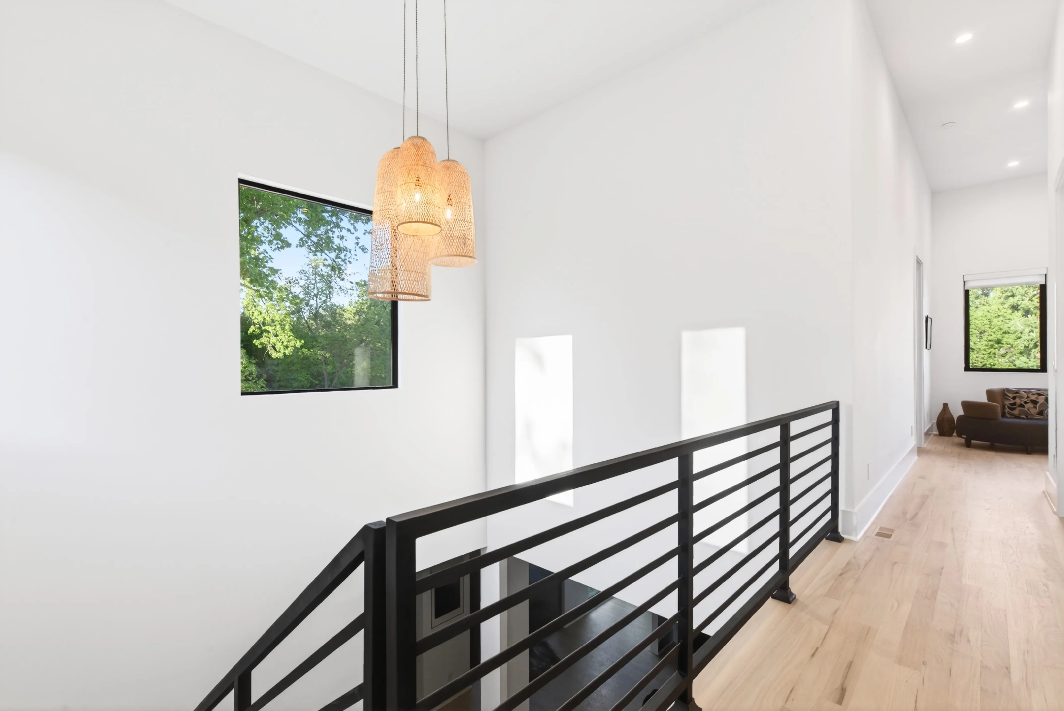 Stairwell with a black metal railing and pendant lights
