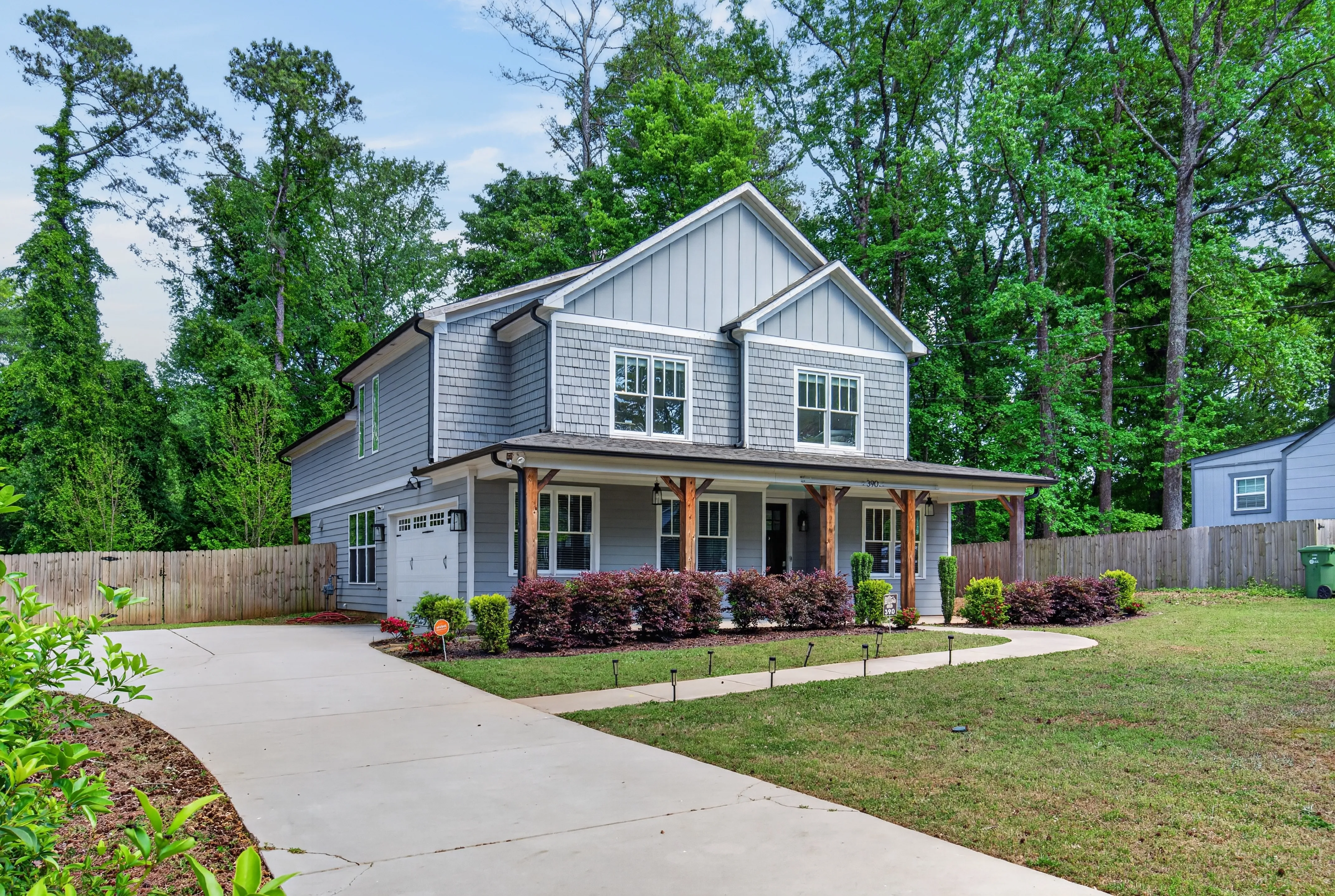 Two-story gray home with a covered front porch and landscaped yard