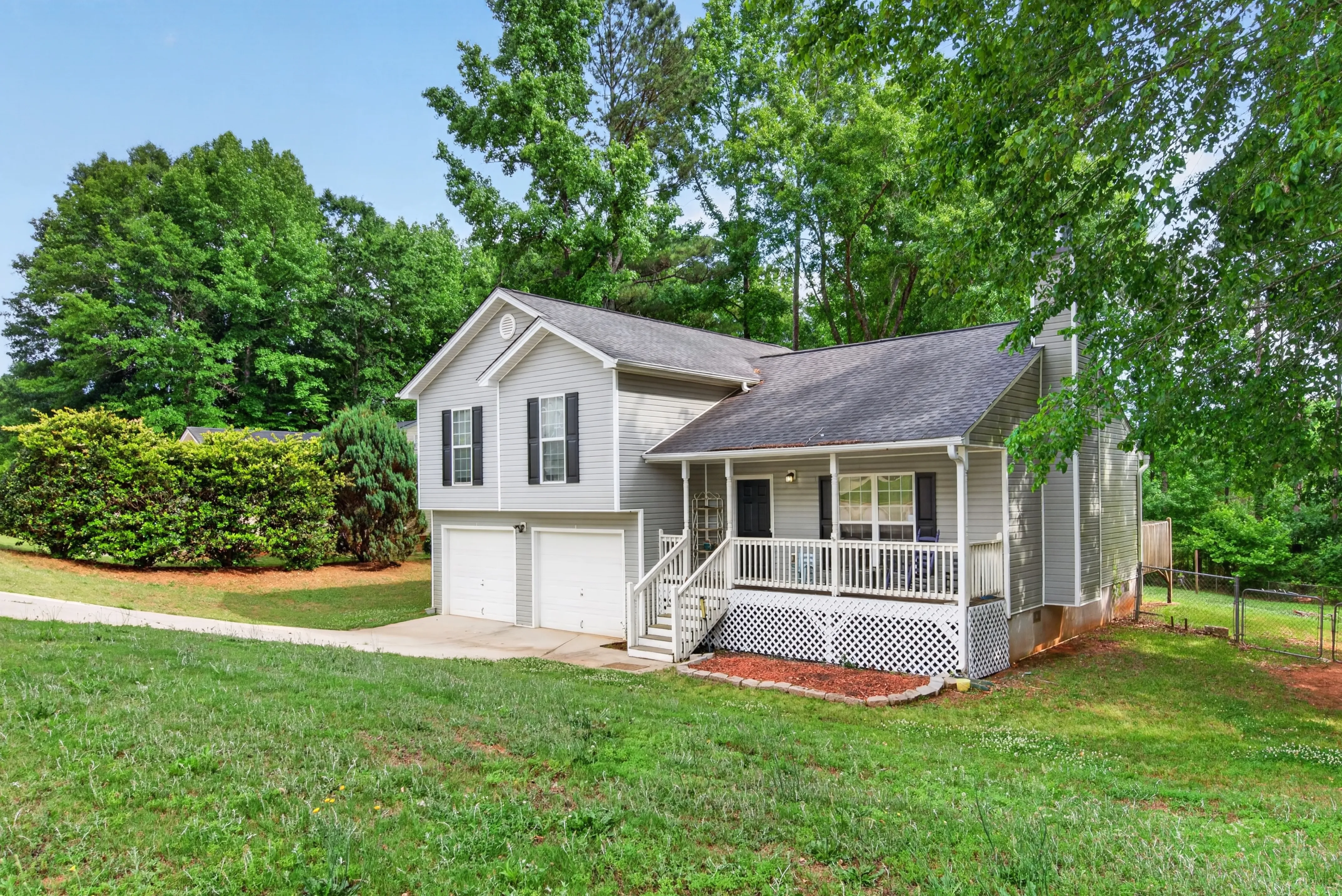 Split-level home with a front porch and broad lawn