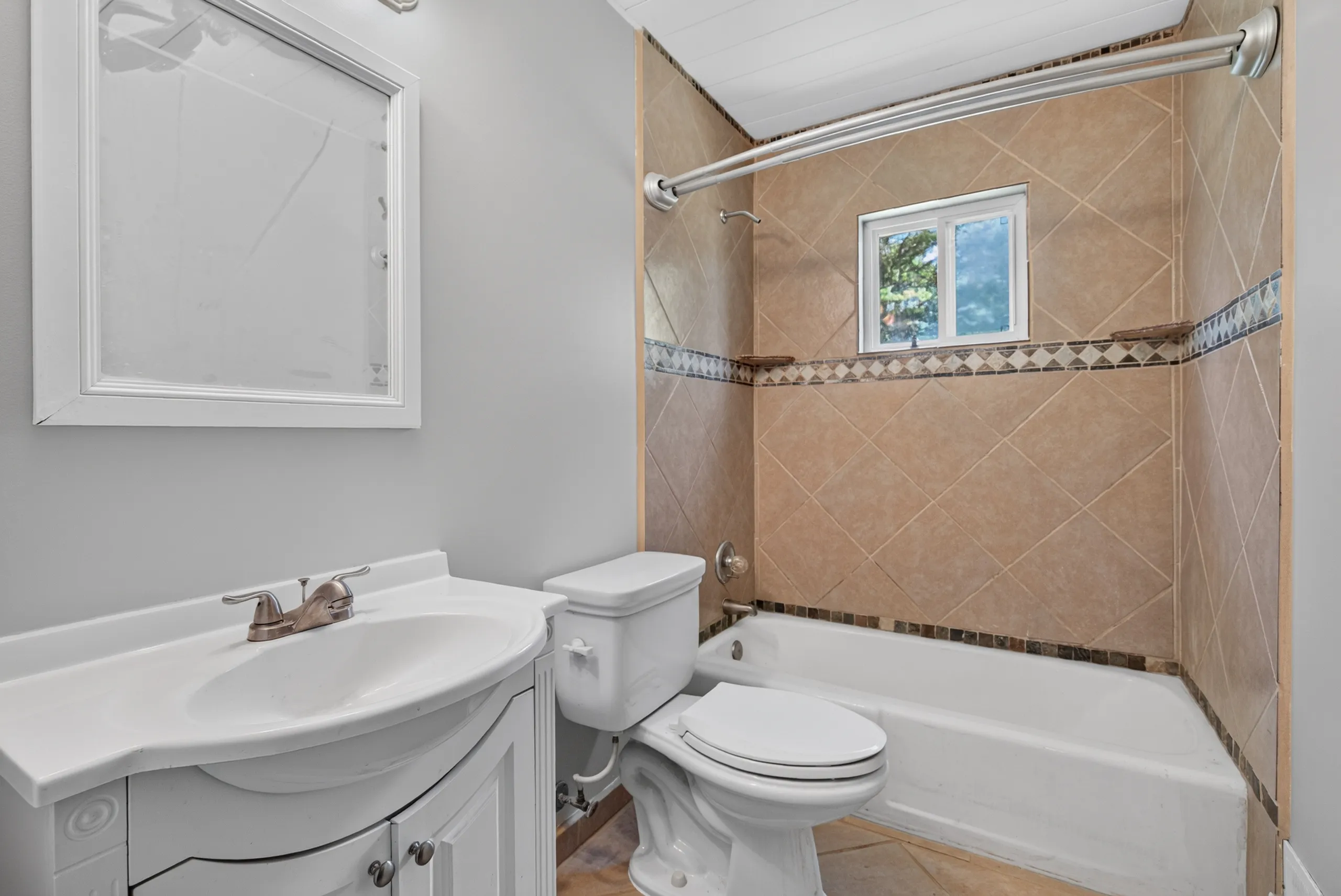Hall bath with a tiled tub-shower and white vanity